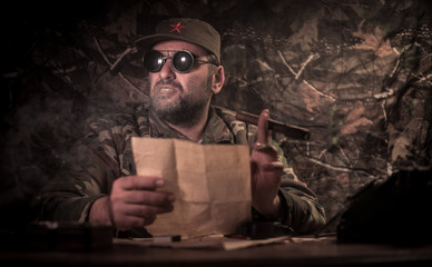 The evil dictator sitting on table. Angry communist general sitting at headquarter or Cuban...