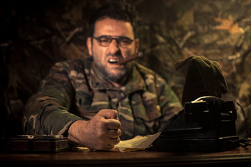 The evil dictator sitting on table. Angry communist general sitting at headquarter or Cuban...