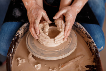 happy family on a creative joint vacation. romantic couple in love working together on potter wheel and sculpting clay pot