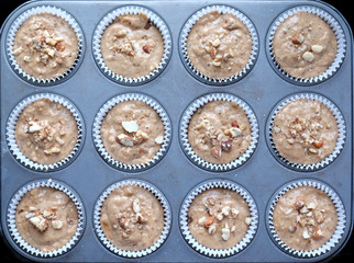 12 cup cakes on a baking tray about to go into the oven