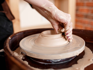 Fototapeta premium Hands sculpt new utensil on a pottery wheel