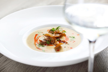 Celery cream soup with baked potatoes and a glass of white wine