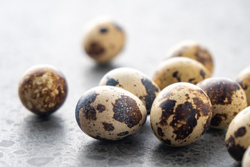 Small quail eggs on the stone background