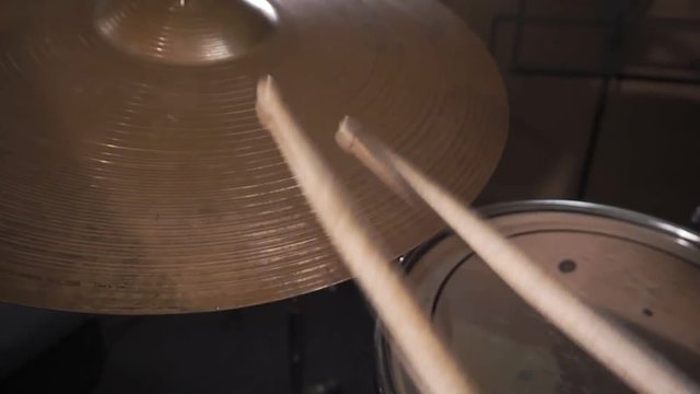 Drummer hitting on wet drum cymbal