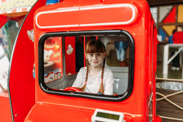 Little girl plays a bus driver, game machine