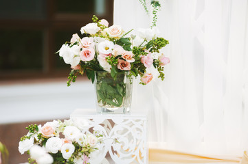 Photo of wedding bouquet of beautiful roses in a glass vase