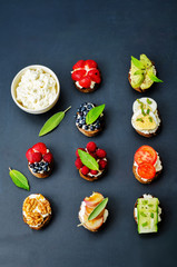 Ricotta and crostini appetizers with fillings on a black background