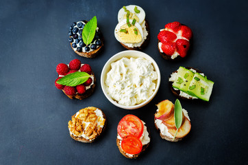 Ricotta and crostini appetizers with fillings on a black background