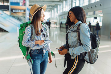 Two female tourists with backpacks in airport