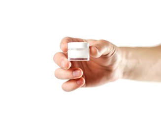 Hand holding white lip balm. Close up. Isolated on white background