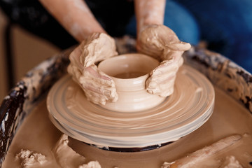 Fototapeta na wymiar Hands sculpt new utensil on a pottery wheel