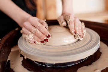 Hands sculpt new utensil on a pottery wheel