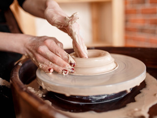 Hands sculpt new utensil on a pottery wheel