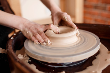 Hands sculpt new utensil on a pottery wheel