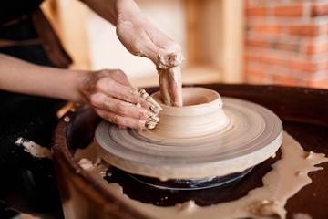 Hands sculpt new utensil on a pottery wheel