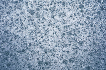 Fototapeta na wymiar Foam blue from soap bubbles as a background for design.