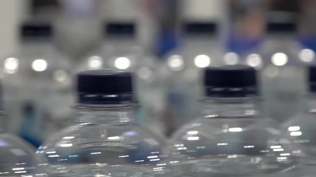Production of drinking water in plastic bottles moving on conveyor belt