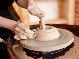 Hands sculpt new utensil on a pottery wheel