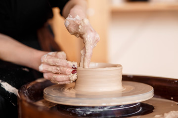 Hands sculpt new utensil on a pottery wheel