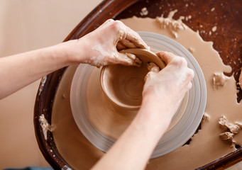Hands sculpt new utensil on a pottery wheel