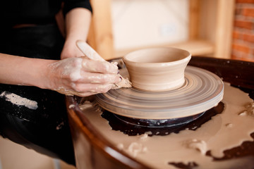 Fototapeta na wymiar Hands sculpt new utensil on a pottery wheel