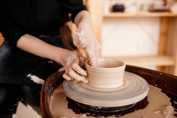 Hands sculpt new utensil on a pottery wheel