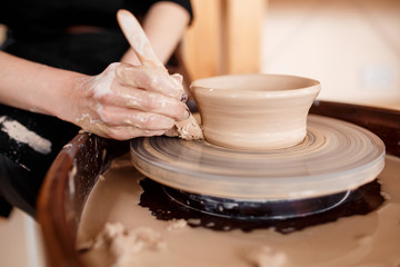 Hands sculpt new utensil on a pottery wheel
