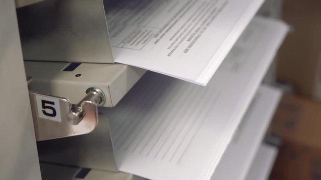 Preparation of equipment for printing books and booklets. Professional printer carriage movement. Printed sheets. Printing on clean sheets.
