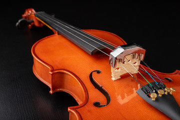 Beautiful new shiny violin on a dark table. Musical string instrument prepared for work.