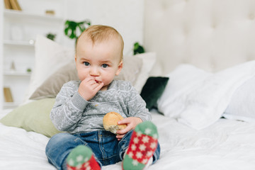 Very cute little toddler boy snacking. Baby or small child eating a piece of bread. Making funny silly face.