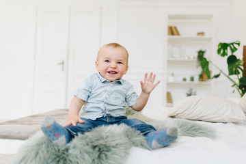 Cute little toddler boy waving his hand. Child waving hello or goodbye.