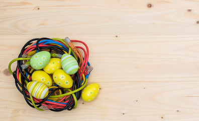 Easter eggs and nest of internet cables on wooden board