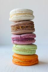 Colorful French or Italian macaroon stack cakes / Macaroon cakes. Assorted macaroon cakes stacked on top of each other on a light background. Copy space. Delicious dessert.