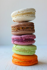 Colorful French or Italian macaroon stack cakes / Macaroon cakes. Assorted macaroon cakes stacked on top of each other on a light background. Copy space. Delicious dessert.