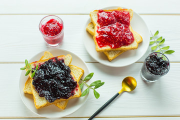 Delicious toast white bread with raspberry and currant jam on wooden table. Food,dessert, homemade food concept