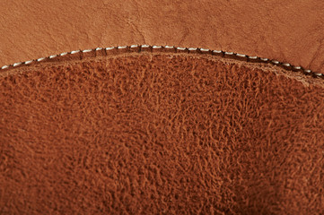 Stitch on brown leather background
