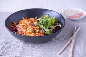 Angled view of donburi salmon on black plate