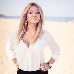  young beautiful woman blonde poses on a beach