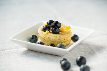 Lemon egg muffin on white plate with blueberries