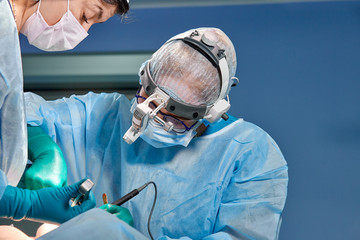 Team of surgeons makes an invasive operation. Portrait of surgeons close-up. Work with a...