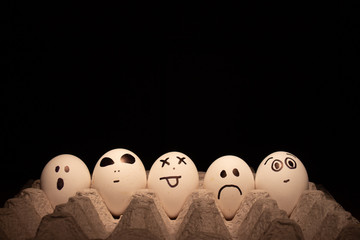 Easter eggs with funny faces on black background.