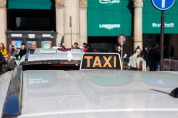 Row of car taxis waiting for customers in front of the cathedral of Milan