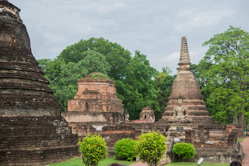 Buildings and stone Buddha symbol at Sukhothai Historical Park in Thailand