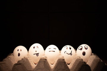 Easter eggs with funny faces on black background.