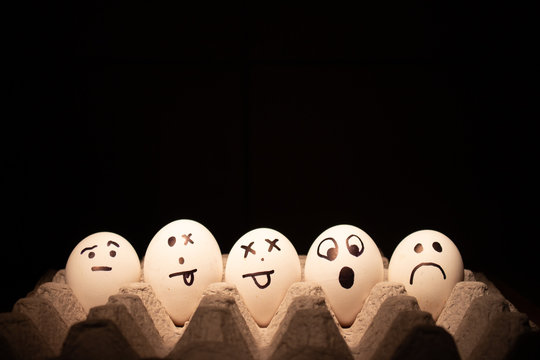 Easter eggs with funny faces on black background.