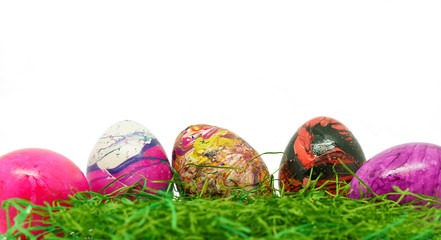 Ostern - Bunte Ostereier im Gras auf weißem Hintergrund