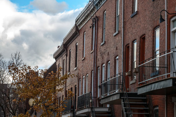 Facades of traditional North American residential buildings, red brick houses, taken in the center of Montreal, the second biggest city of Canada, and a business hub of Canada