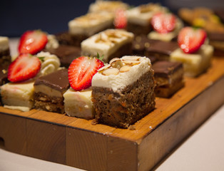 Closeup chocolate cake slices wooden tray strawberries background 