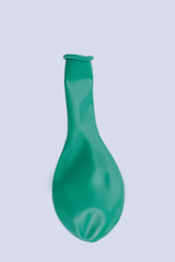 Deflated green balloon isolated on white. Green airless balloon, vertical image. Symbol of Birthday celebration.