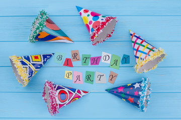 Birthday party composition with cardboard hats. Flat lay colorful party caps and inscription...